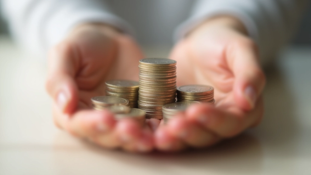 Mains tenant des pièces de monnaie représentant l'épargne progressive